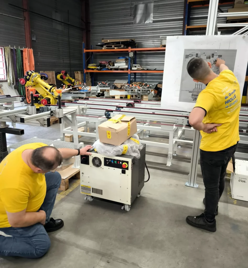 Deux membres de l'équipe Hiolle entrain de travailler avec leur maillot jaune remis par LCL en collaboration avec le Tour de France