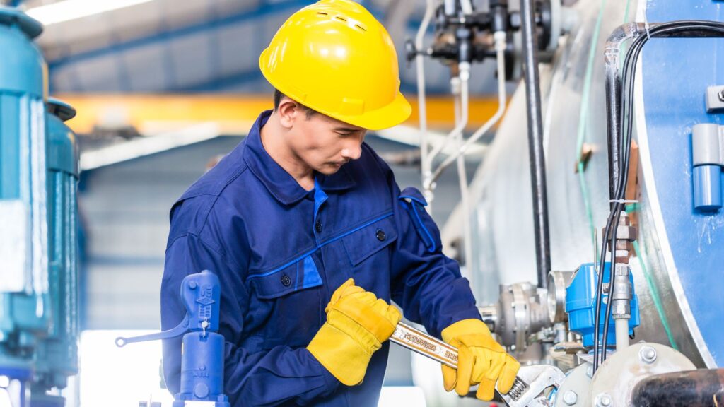 Un homme en bleu et jaune qui fait de la maintenace préventive